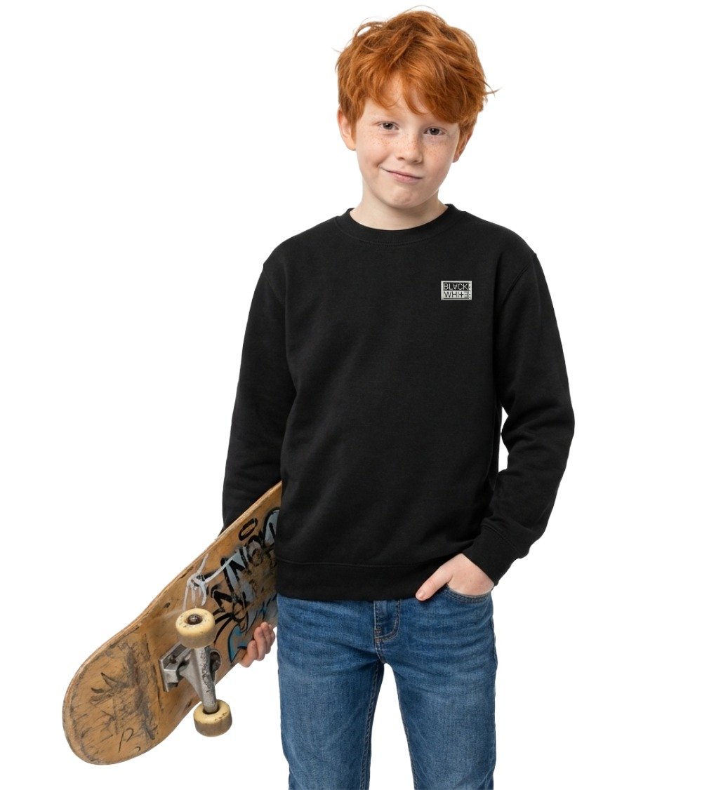 Ginger boy holding skateboard wearing Kid's Origin Patch Organic Sweatshirt in Black with woven Black White Jeans logo
