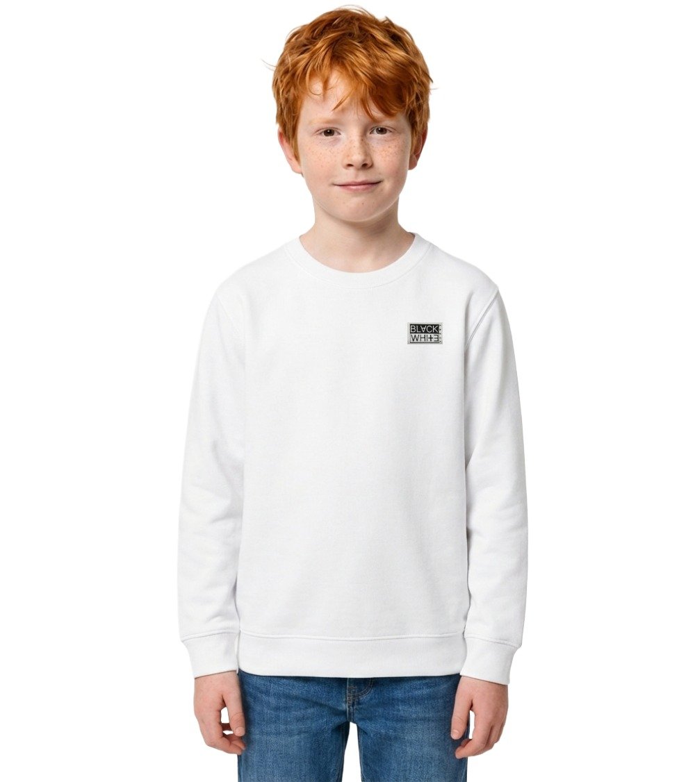 Ginger boy wearing kid's origin organic white sweatshirt with woven patch